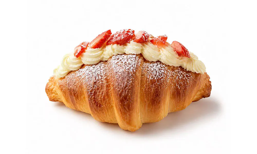 Flaky butter croissant filled with whipped cream and fresh sliced red strawberry toppings at Sweet Cottage Cafe, a Dessert shop in Lexington